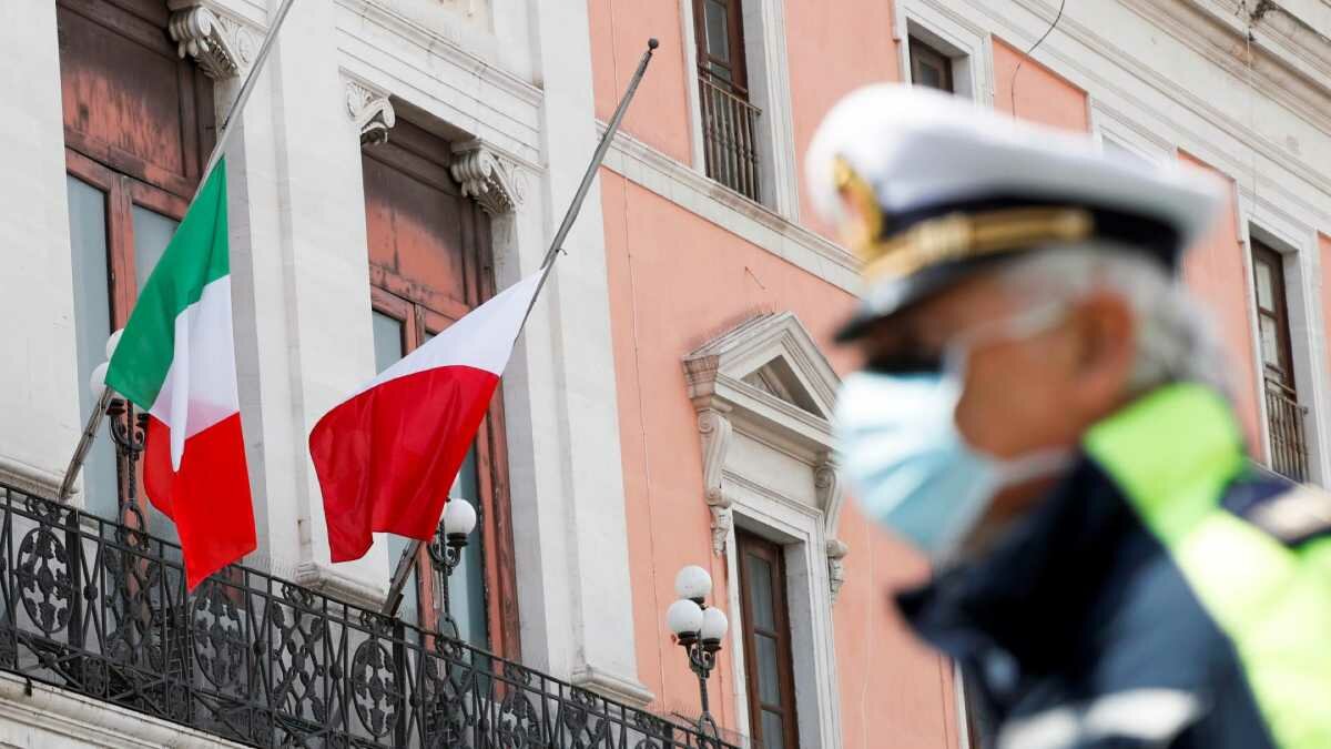 Oficial de policía con máscara contra el fondo de la bandera italiana