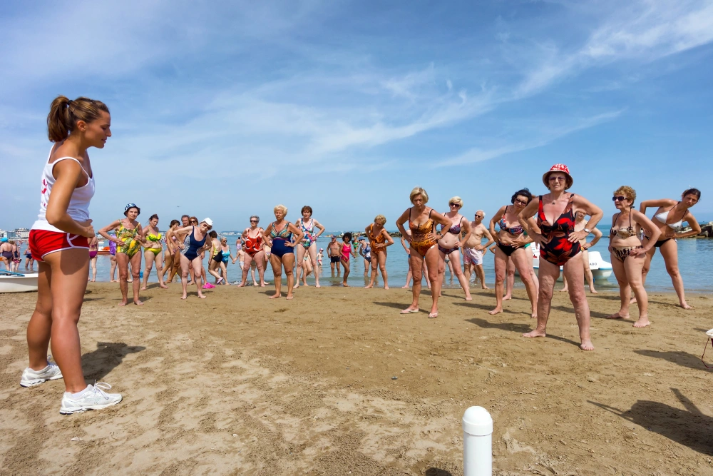 Idosos praticando exercícios físicos na praia de Cattoica, Emilia Romagna