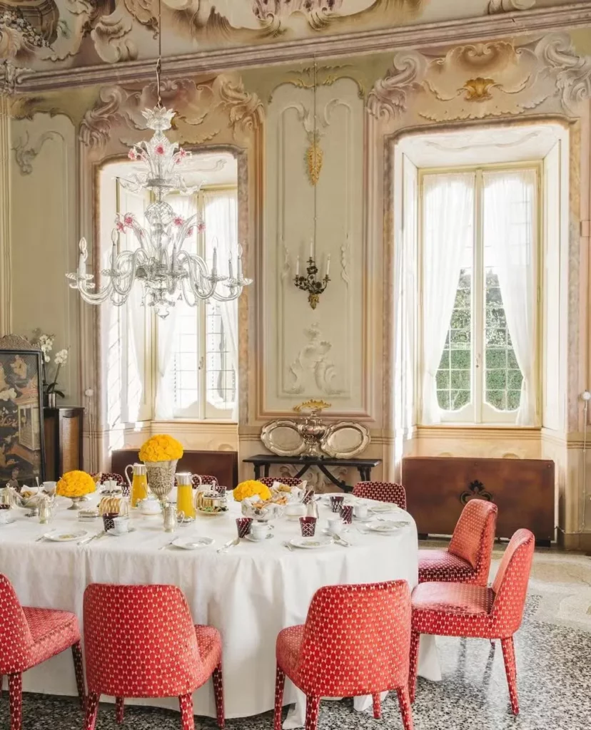 A sala de jantar clássica tem cadeiras vermelhas estampadas — Foto: Instagram / @villasolacabiati / Reprodução