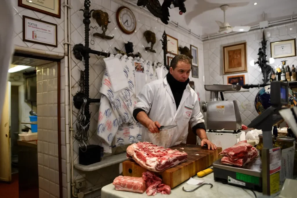 Um funcionário do açougue Antica Macelleria Annibale de Roma fotografado no trabalho em fevereiro de 2018. Foto de Alberto PIZZOLI / AFP
