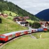 Viagem de trem: descubra paisagens deslumbrantes entre a Itália e outros países europeus em 2025. Na imagem, um trem cruza as montanhas na fronteira entre Itália e Áustria | Foto: Depositphotos