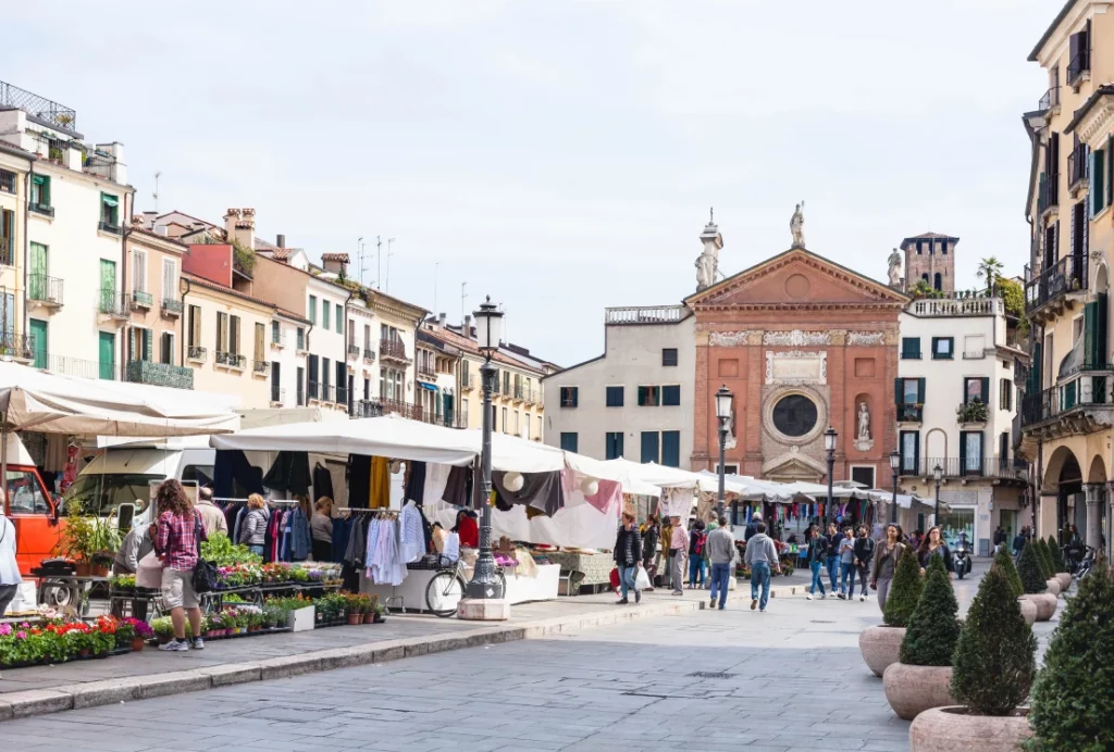 Movimento no mercado de rua na Piazza dei Signori, em Padova, onde a diversidade cultural é refletida no cotidiano da cidade | Foto: Depositphotos 