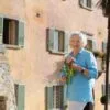 Frances Mayes em frente à sua casa restaurada em Cortona, na Toscana, cenário de sua obra mais conhecida | Foto: Marco Sallee/Indagare