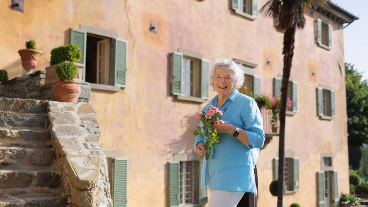 Frances Mayes em frente à sua casa restaurada em Cortona, na Toscana, cenário de sua obra mais conhecida | Foto: Marco Sallee/Indagare