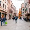 Casal caminha por rua comercial em Veneza, cidade muito procurada por estrangeiros que desejam investir em imóveis na Itália | Foto: Depositphotos