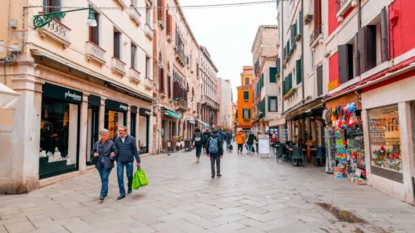 Casal caminha por rua comercial em Veneza, cidade muito procurada por estrangeiros que desejam investir em imóveis na Itália | Foto: Depositphotos