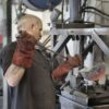 rabalhador opera máquina em indústria metalúrgica na Itália, setor que contribui para a recuperação do emprego no país