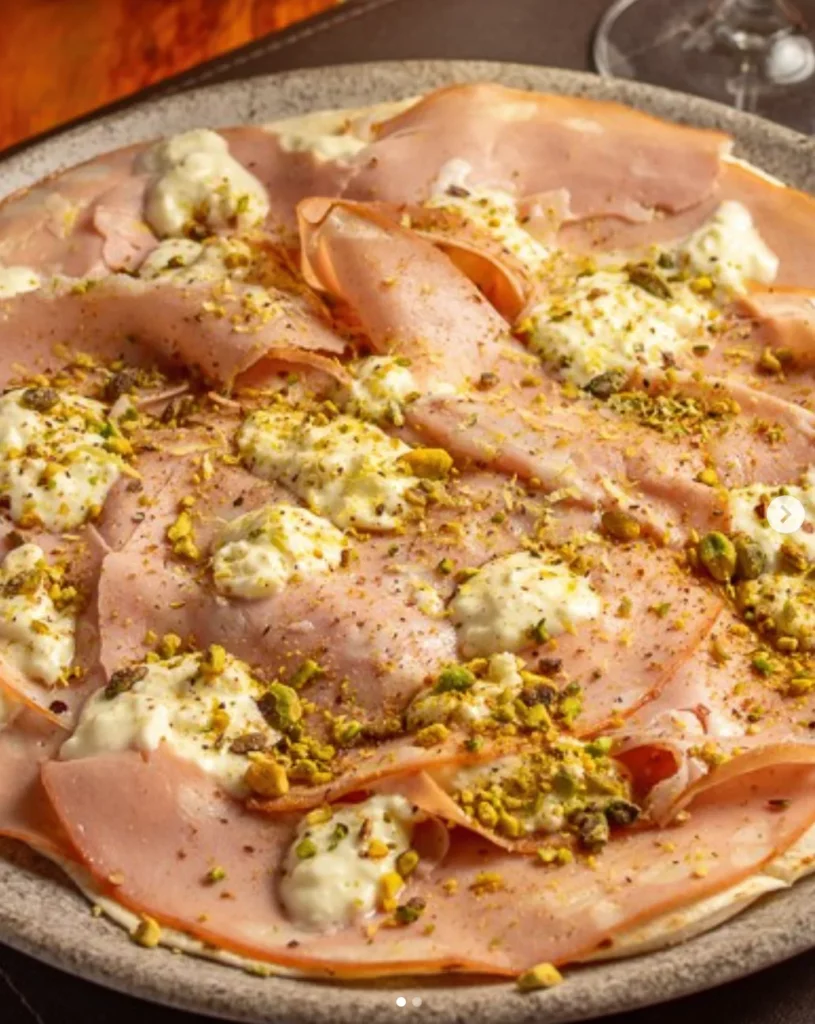Pizza Roma, que leva mortadela italiana, stracciatella cremosa, pistache e raspas de limão siciliano