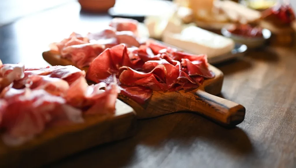 A tradicional bresaola, carro-chefe da gastronomia local, é protegida por consórcio regional.