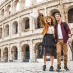 Casal de turistas observa o Coliseu, em Roma, durante passeio pelo principal símbolo da capital italiana.