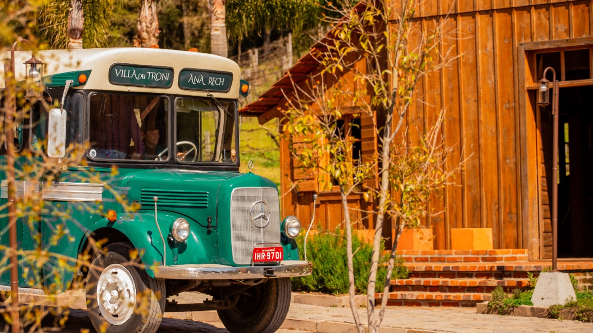Ônibus histórico da linha Ana Rech–Caxias conduz visitantes na Villa dei Troni, parque temático da cultura italiana na Serra Gaúcha.