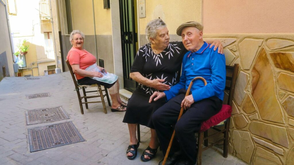 Idosos aproveitam a sombra nas ruas estreitas de Nicósia, uma pequena cidade da Sicília, cenário típico do interior italiano | Depositphotos