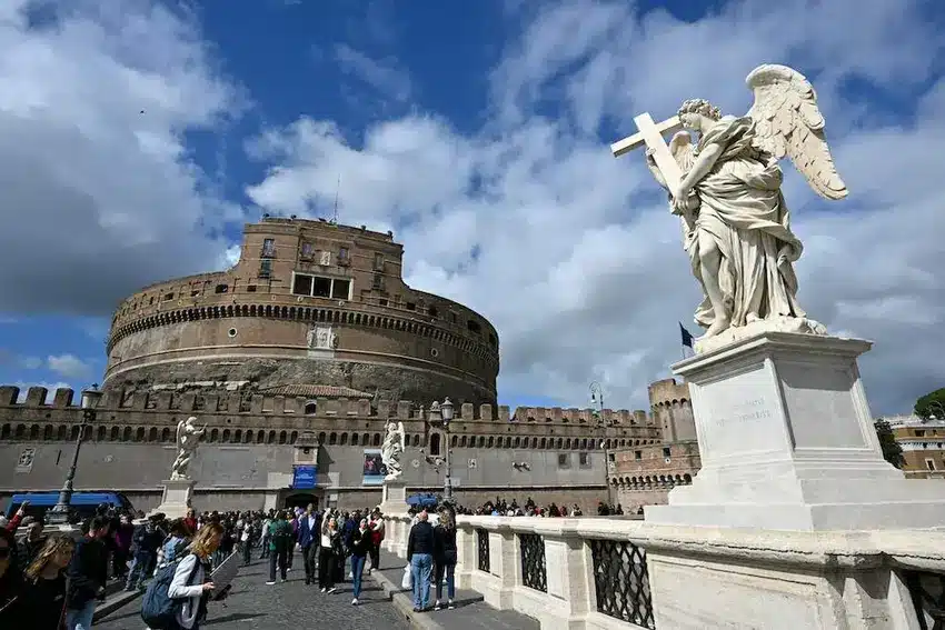 Turistas caminham pela ponte do Castelo de Santo Ângelo em Roma, em 18 de abril de 2025. Foto de Alberto Pizzoli / AFP.