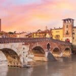 Ponte Pietra ao entardecer, em Verona, com o rio Ádige e o centro histórico ao fundo. A cidade italiana conquistou o 4º lugar no European Best Destinations 2026.