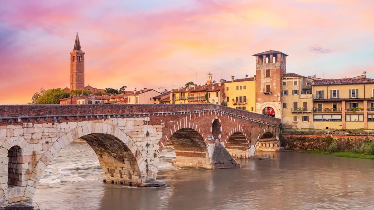 Ponte Pietra ao entardecer, em Verona, com o rio Ádige e o centro histórico ao fundo. A cidade italiana conquistou o 4º lugar no European Best Destinations 2026.