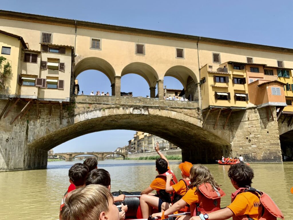 Crianças navegam pelo Rio Arno sob o Ponte Vecchio, em Florença, eleita a melhor cidade italiana para crianças em 2026