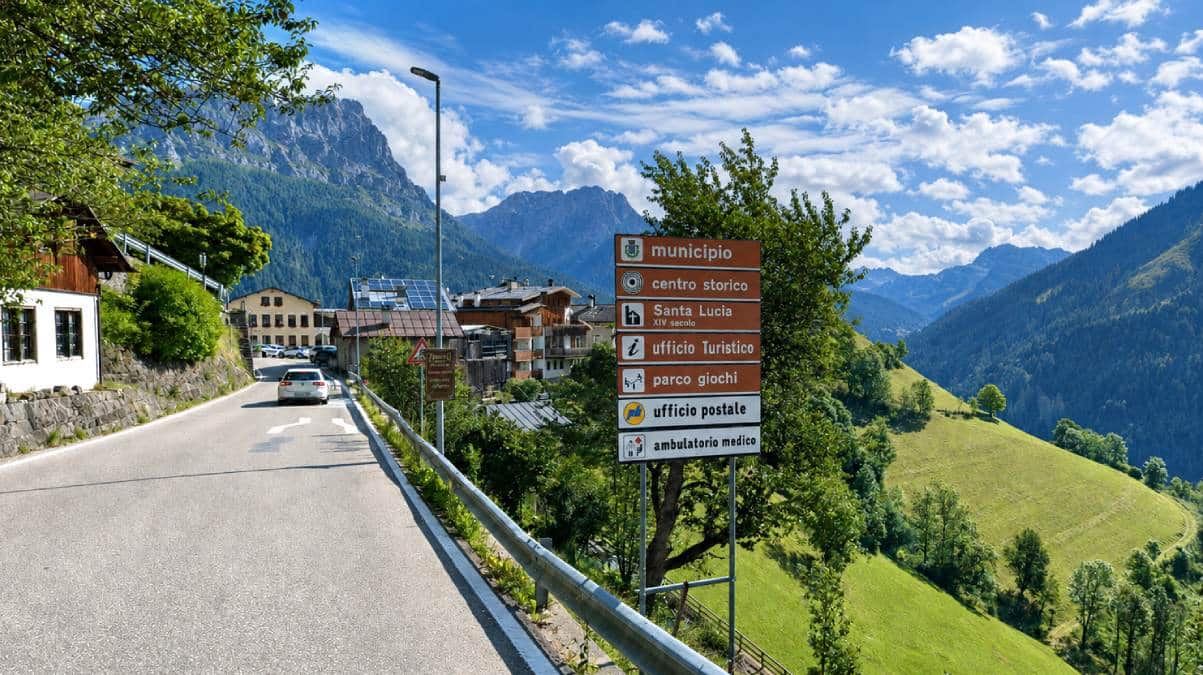Placas de sinalização na entrada de Colle Santa Lucia, na província de Belluno (Vêneto), município alpino que transformou um único radar em sua principal fonte de receita entre 2021 e 2025. (Crédito: Google Street View.)