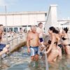 Frequentadores na praia do Pedocin, em Trieste (Itália), durante a temporada de verão, onde uma estrutura separa as áreas destinadas a homens e mulheres.