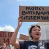 "Protejam a cidadania por nascimento", diz o cartaz erguido por manifestante em frente à Suprema Corte dos EUA, em Washington, durante protesto em defesa da 14ª Emenda.