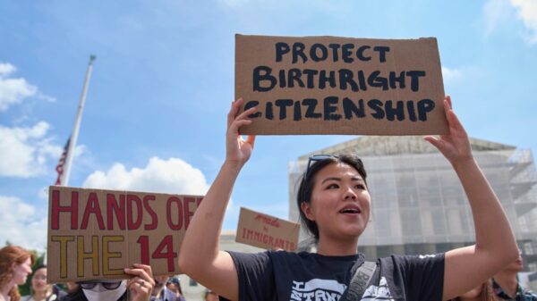 "Protejam a cidadania por nascimento", diz o cartaz erguido por manifestante em frente à Suprema Corte dos EUA, em Washington, durante protesto em defesa da 14ª Emenda.