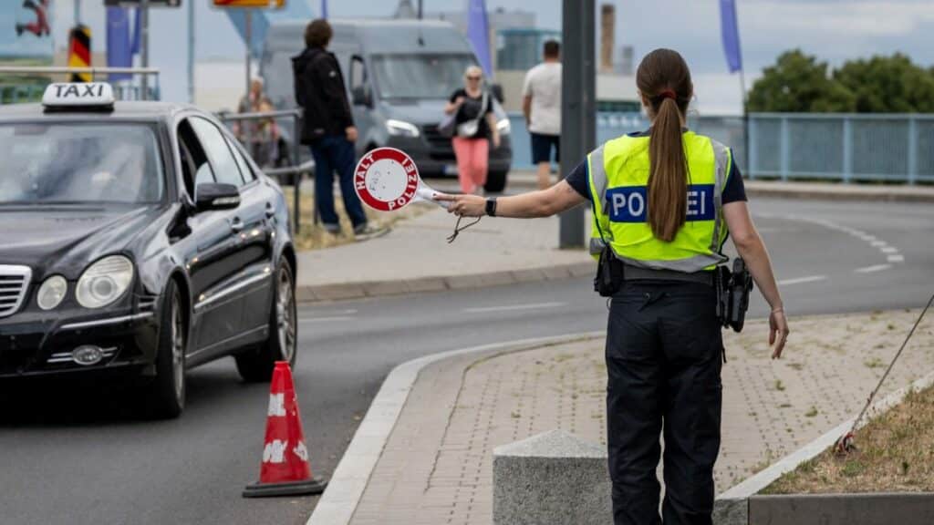 Policial alemã realiza controle de fronteira interna na Alemanha, em julho de 2025, prática que a União Europeia quer ver suspensa de forma gradual. (Foto: AFP)