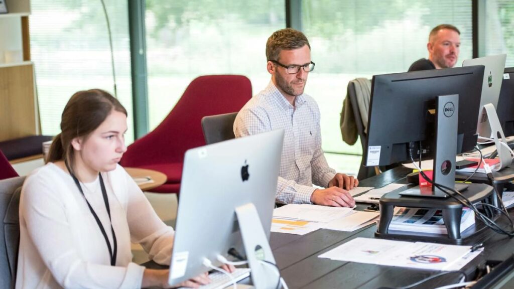 Trabalhadores em ambiente corporativo europeu representando o desafio de recrutamento de mão de obra qualificada nas PMEs da UE.