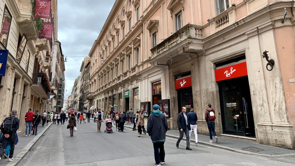 Pedestres caminham pela Via del Corso, no centro de Roma. A rua concentra parte do comércio que reduz o horário no feriado de 2 de junho.