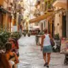 Turistas circulam por uma rua movimentada durante o verão europeu, período em que a conectividade móvel se tornou parte essencial dos roteiros entre diferentes países.