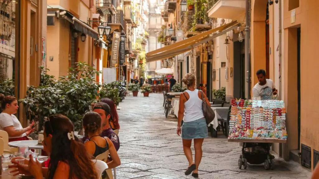 Tourists stroll along a busy street during the European summer, a period when mobile connectivity has become an essential part of travel between different countries.