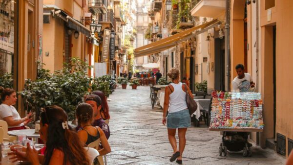 Tourists stroll along a busy street during the European summer, a period when mobile connectivity has become an essential part of travel between different countries.