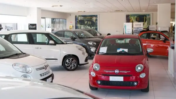 Modelos da Fiat expostos em concessionária; compra de carro na Itália envolve custos com financiamento, transferência, seguro e impostos