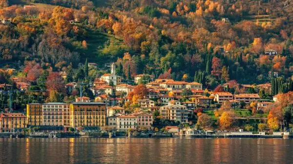 Paisagem de outono às margens do Lago de Como, no norte da Itália, com árvores em tons de amarelo, laranja e vermelho nas encostas | Foto: Depositphotos