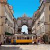 Elétrico cruza a Rua Augusta, no centro histórico de Lisboa, com o Arco da Rua Augusta ao fundo | Foto: Reprodução/Secrets From Portugal