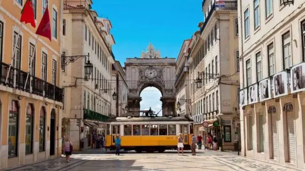 Elétrico cruza a Rua Augusta, no centro histórico de Lisboa, com o Arco da Rua Augusta ao fundo | Foto: Reprodução/Secrets From Portugal
