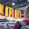 Passageiro observa painel de voos em aeroporto antes de embarcar para a Europa | Foto: Depositphotos