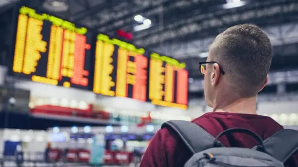 Passageiro observa painel de voos em aeroporto antes de embarcar para a Europa | Foto: Depositphotos