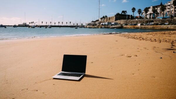 Notebook na areia em Cascais, Portugal, destino procurado por profissionais que trabalham remotamente | Foto: Depositphotos