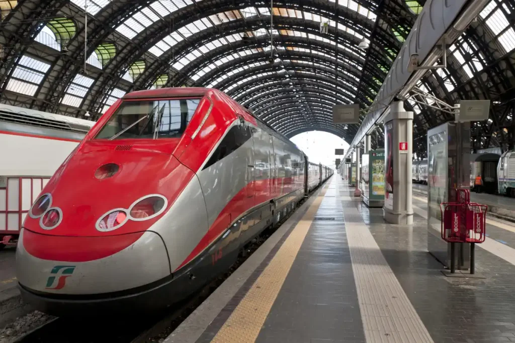 Trem de alta velocidade parado na plataforma da estação Milano Centrale.