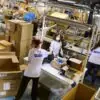 Trabalhadores atuam na separação e no processamento de encomendas em um centro de logística dos Correios de Portugal (CTT) | Foto: Divulgação/CTT