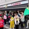 Eleitores brasileiros com bandeiras do Brasil e camisetas de apoio aos candidatos se reúnem nas proximidades do local de votação em Milão, durante o segundo turno das eleições presidenciais, neste domingo (25)