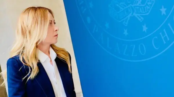 A primeira-ministra da Itália, Giorgia Meloni, diante do símbolo oficial da Presidência do Conselho de Ministros, em Roma | Foto: Divulgação/Governo italiano