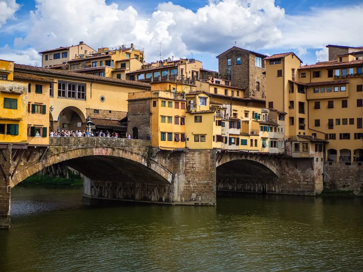 Turistas atravessam a Ponte Vecchio, sobre o rio Arno, em Florença